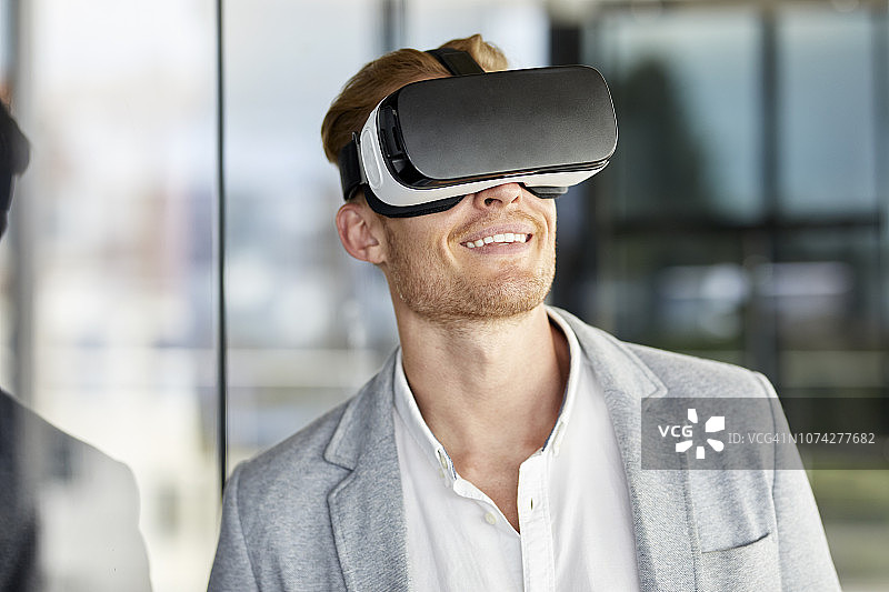 微笑的商人戴着VR眼镜图片素材
