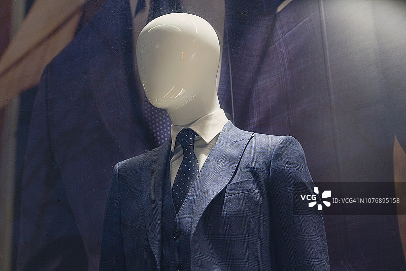 商店橱窗里穿着优雅套装的男性人体模型。时尚图片素材