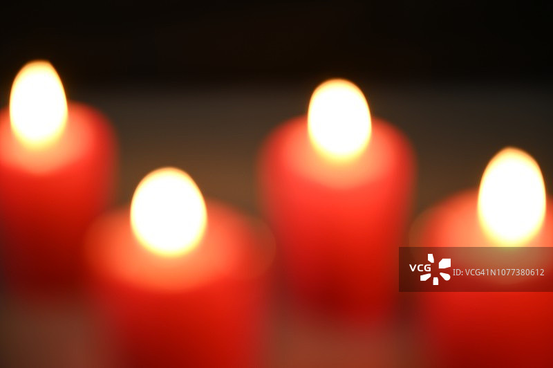 形状的四个蜡烛与一个点燃的火焰。图片素材