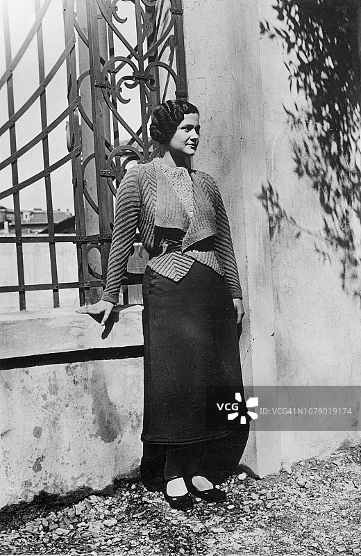 1930年代。佛罗伦萨托斯卡纳意大利年轻女子肖像在家草地上图片素材