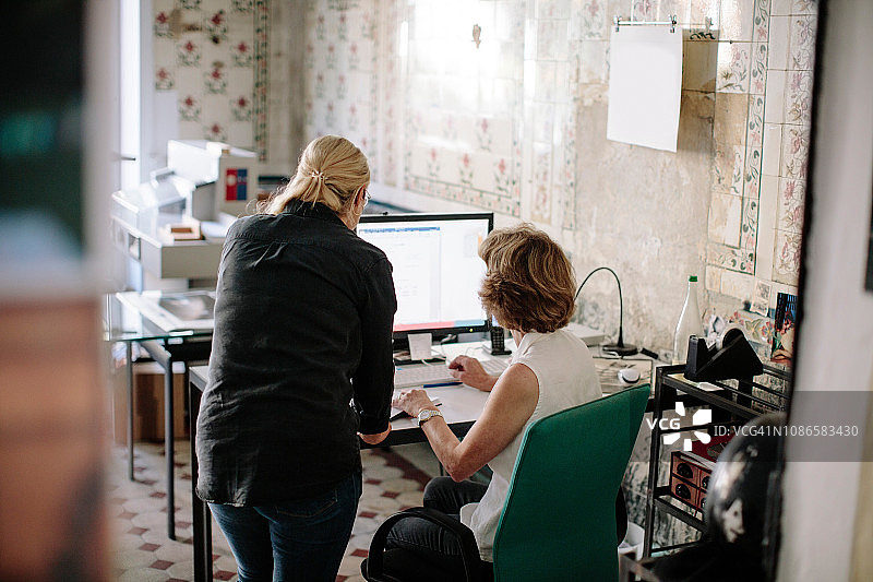 高级女商人和同事在设计工作室通过电脑讨论图片素材