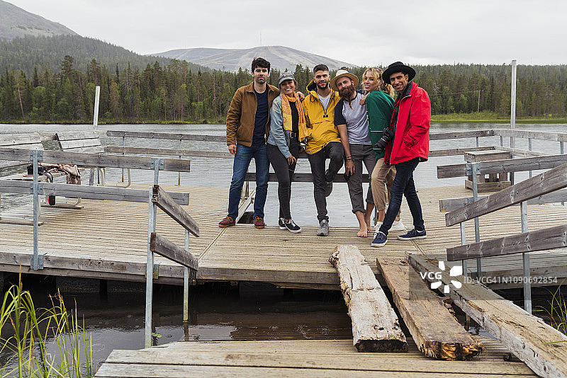 芬兰，拉普兰，朋友们站在湖边码头上的肖像图片素材