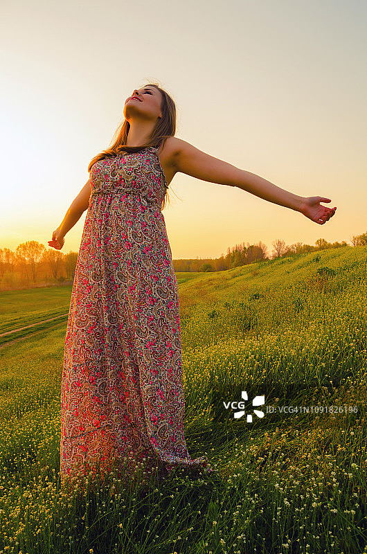 快乐的女人穿着衣服站在草地上图片素材