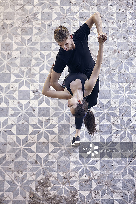 高角度观看芭蕾舞者在旧建筑地板上一起跳舞图片素材