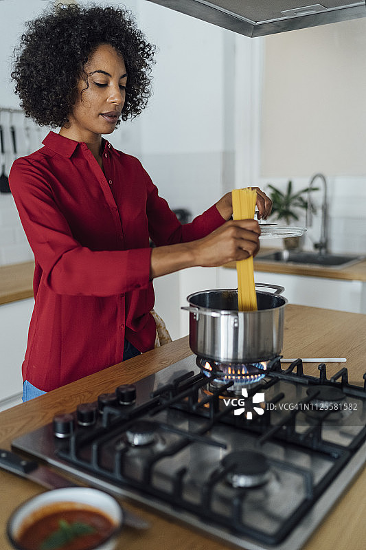 一个女人站在厨房里准备意大利面图片素材