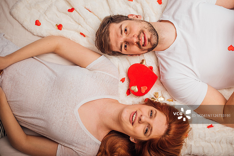 一对幸福的夫妇躺在玫瑰花瓣上图片素材