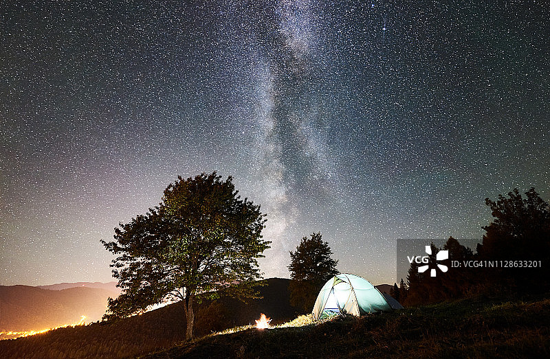在满是星星的夜空下，游客露营和帐篷图片素材