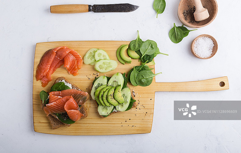 用烟熏鲑鱼和绿色蔬菜准备健康的三明治图片素材