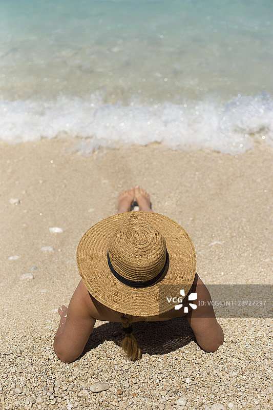 戴着夏天帽子的女人在海滩上图片素材