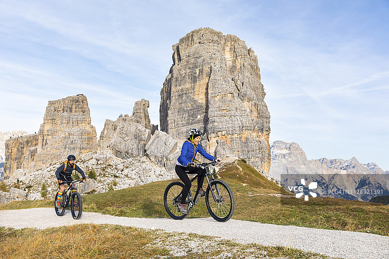 意大利，Cortina d’ampezzo，两个人在Dolomites山区骑山地车图片素材