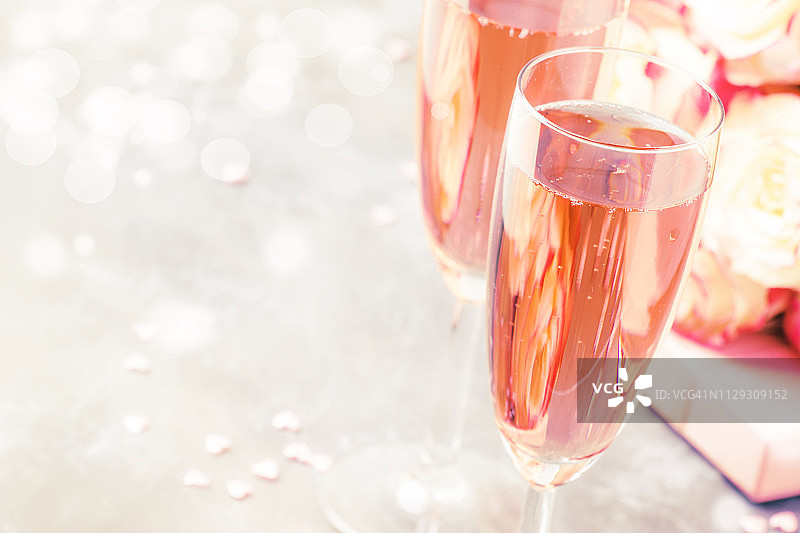 爱的象征-白色和红色的玫瑰花束，礼盒，眼镜与粉色或玫瑰香槟或起泡酒的情人节，婚礼，灰色背景，选择性的焦点图片素材