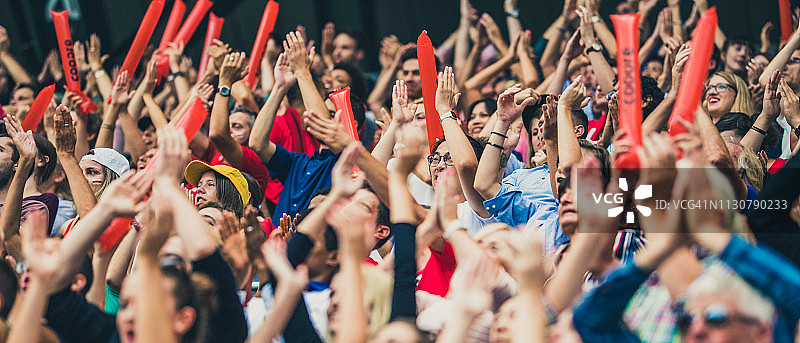人群举起手臂为他们的球队欢呼图片素材