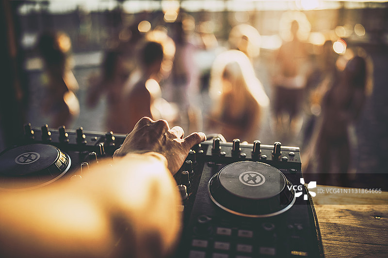 一个DJ在海滩派对上播放音乐的特写。图片素材