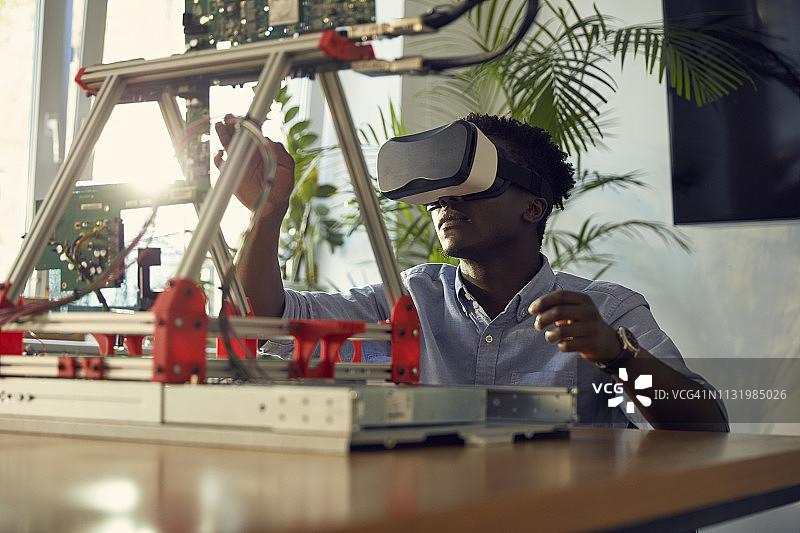 年轻的非洲裔男子使用虚拟现实眼镜。制作设备原型图片素材