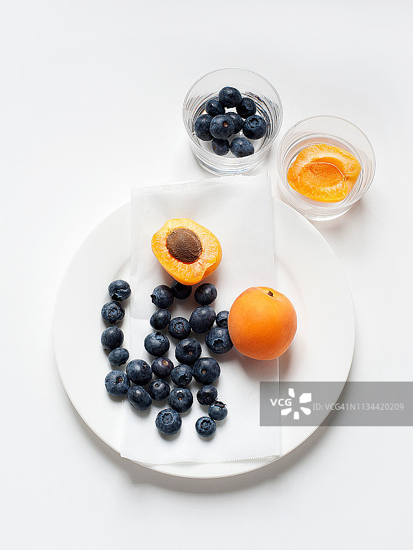 一盘杏子和蓝莓的静物画图片素材