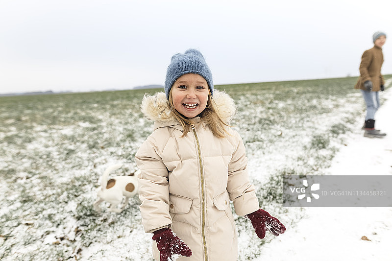 肖像快乐的女孩与狗和兄弟在冬天的风景图片素材
