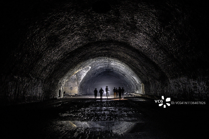 废弃的地下隧道里人们的剪影图片素材