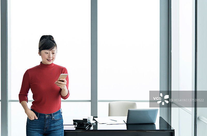 女性在办公室使用智能手机图片素材