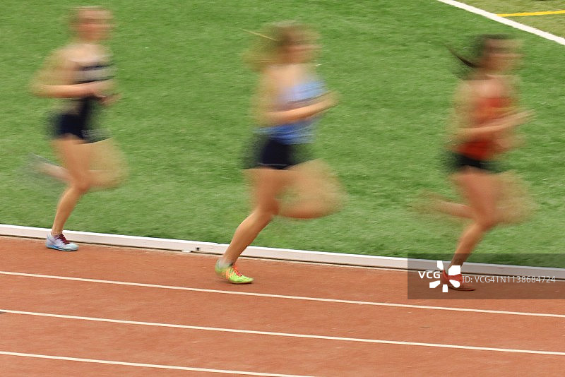 运动员在田径场上赛跑，动作模糊图片素材