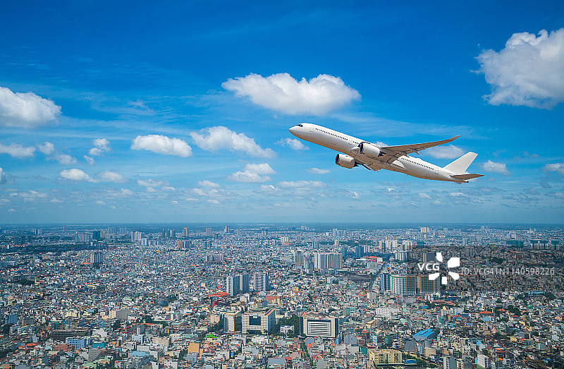 商业飞机在城市上空飞行图片素材