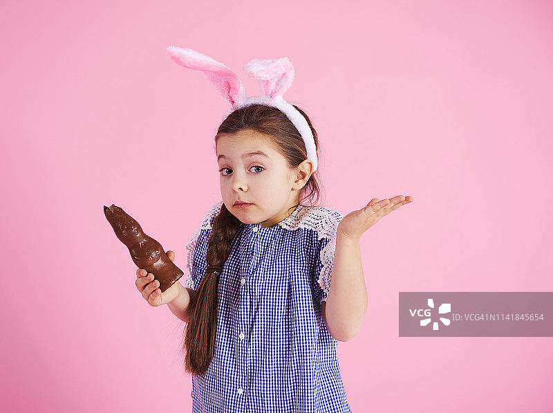 迷茫的女孩在摄影棚里吃巧克力兔子。Debica、波兰图片素材