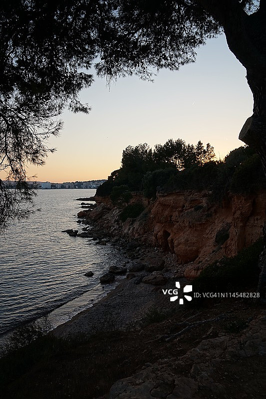 西班牙马略卡岛日落时帕尔马诺瓦附近的岩石海滩图片素材