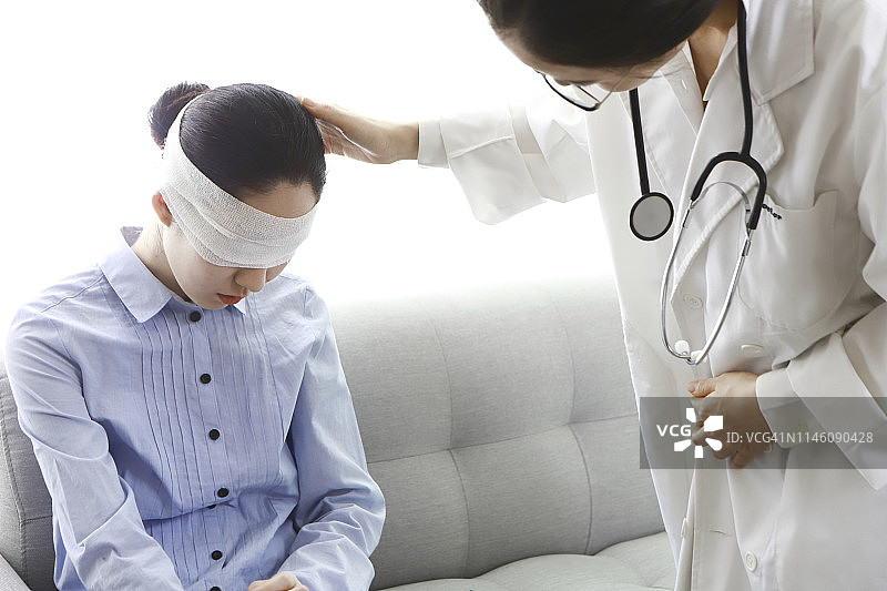 医生检查头部包扎的病人图片素材