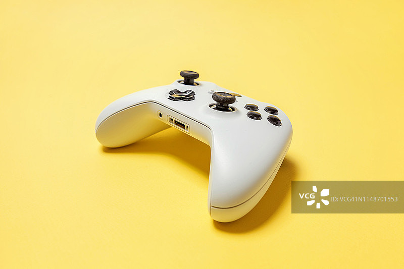 黄色背景上的白色操纵杆。电脑游戏竞赛电子游戏控制对抗概念图片素材