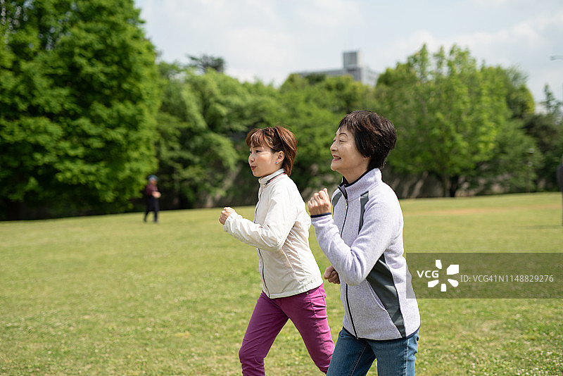 老女人在公园跑步和私人教练图片素材