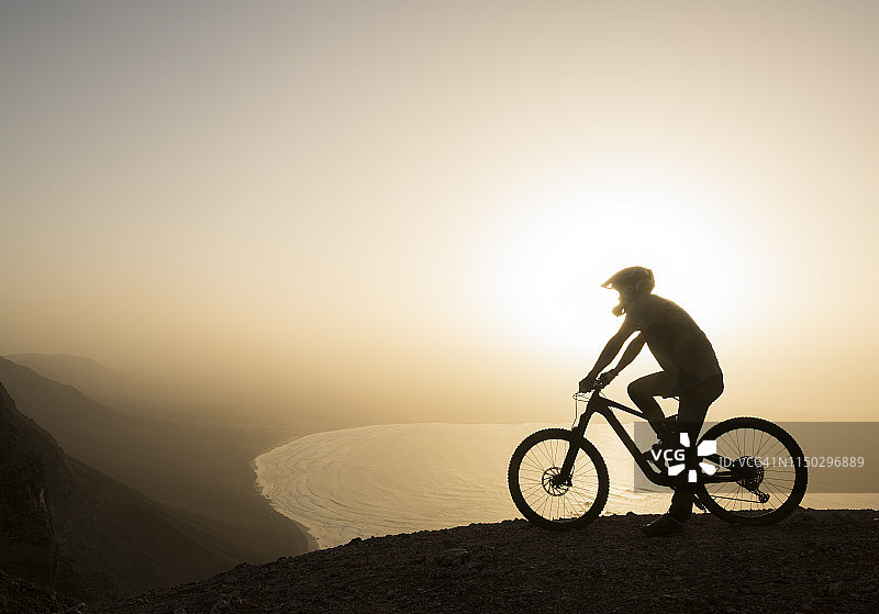 西班牙，兰萨罗特，在日落时分的海岸上骑山地车旅行图片素材