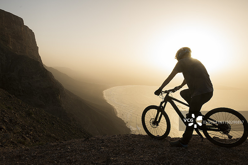 西班牙，兰萨罗特，登山运动员在海边旅行在日落欣赏风景图片素材