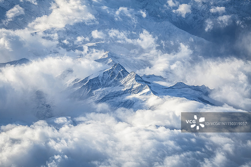 鸟瞰图的雪山在云，奥地利阿尔卑斯山，奥地利图片素材