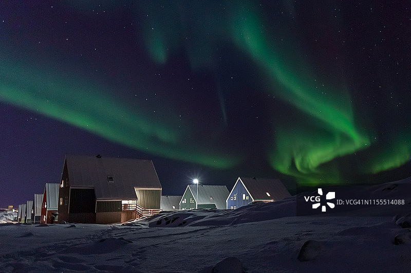格陵兰努克郊区的北极村庄和因纽特人房屋上空的北极光图片素材