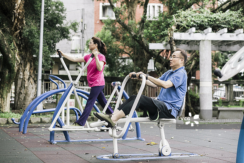一对老夫妇在公园里用器械锻炼身体图片素材