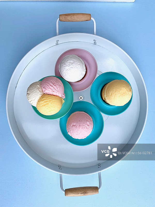 冰淇淋球在木托盘，从上看，在蓝色的背景图片素材