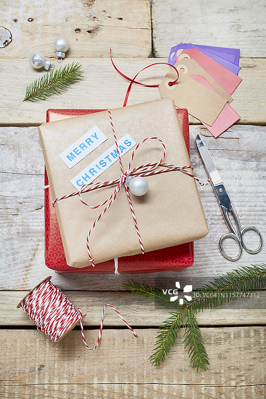 用“圣诞快乐”的文字、剪刀和绳子包装圣诞礼物的静物生活图片素材