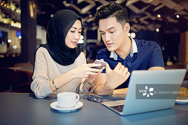 一对年轻的马来西亚夫妇在咖啡馆里聊天图片素材