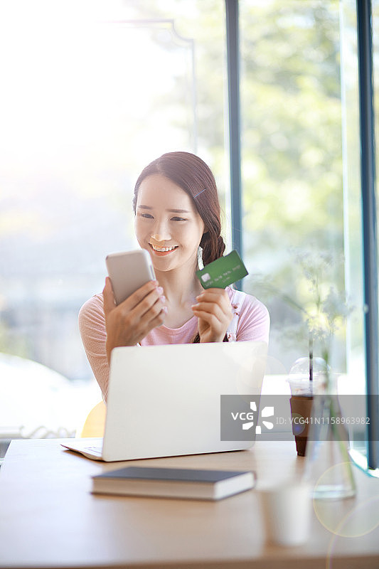女人用智能手机和信用卡在网上购物图片素材
