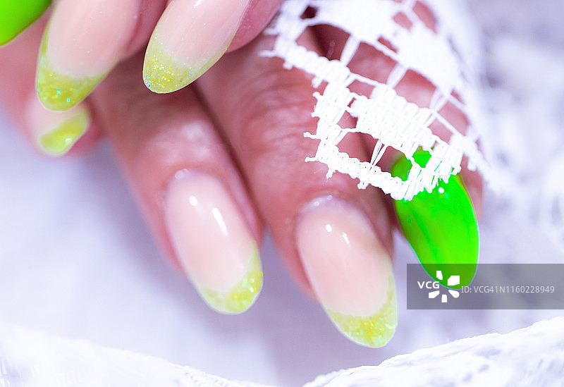 特写的女人的手指与指甲艺术美甲与霓虹灯绿色图片素材