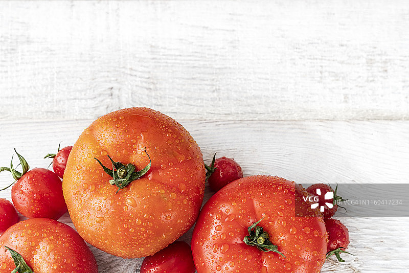 几个不同大小的西红柿放在一个白色的木盘子里图片素材