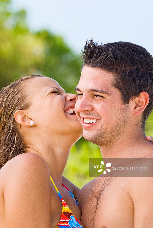 一对幸福的情侣在热带海滩拥抱图片素材