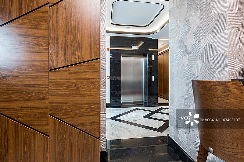 有电梯的闪亮大理石酒店走廊的内部图片素材