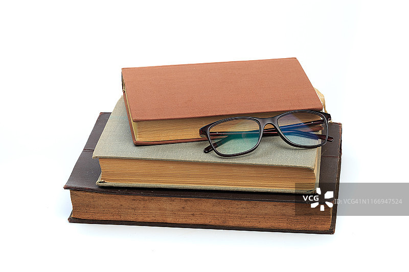 复古的旧精装书与眼镜在白色的背景-图像图片素材