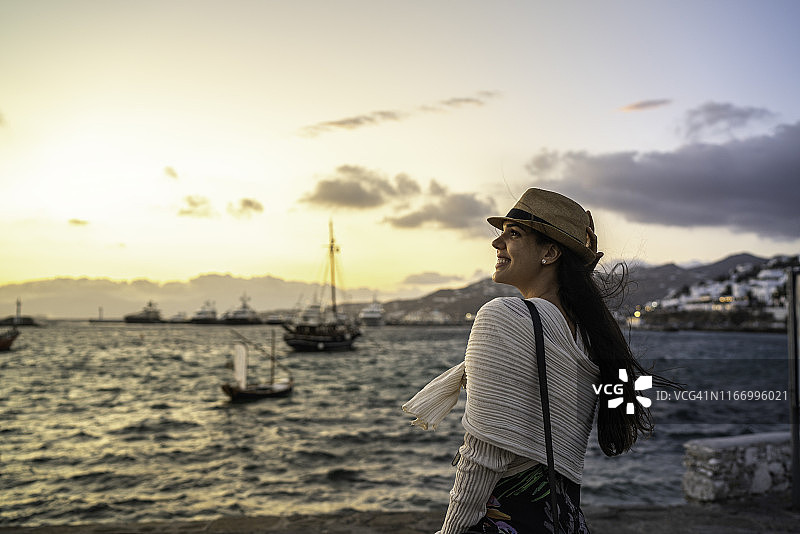 希腊米科诺斯，一位年轻女子在海边欣赏风景图片素材