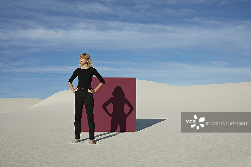 一名年轻女子双手叉腰站在沙漠的栗色入口前图片素材