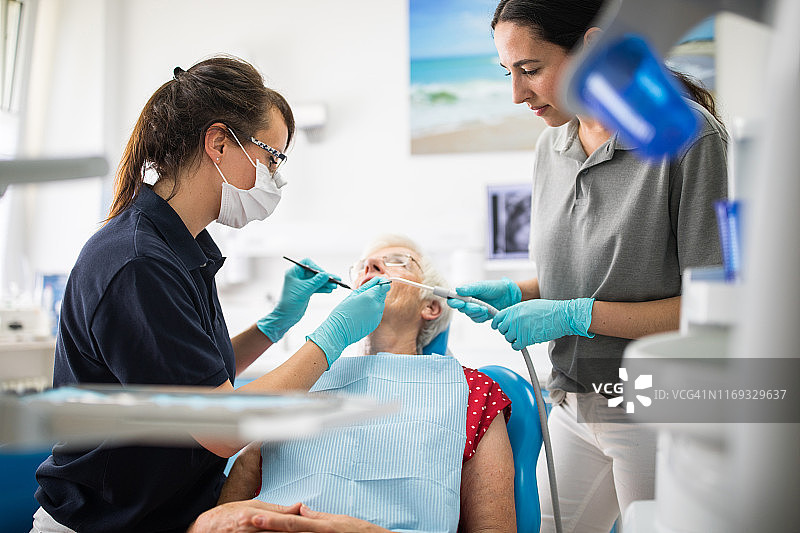 牙科同事治疗资深女性病人图片素材