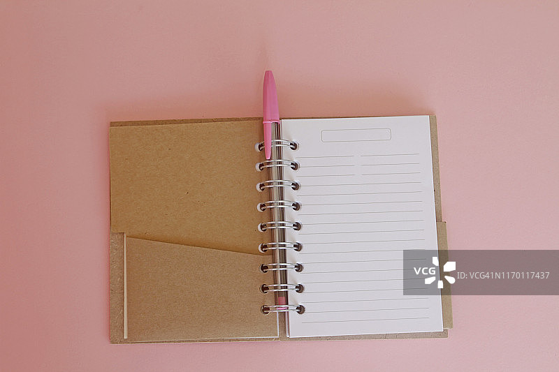 粉色背景的笔记本和笔图片素材
