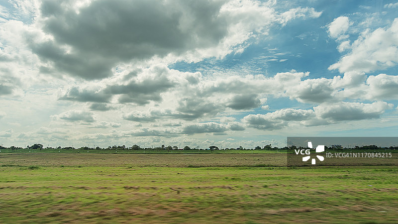 绿色的田野，蓝色的天空，多云的景观图片素材