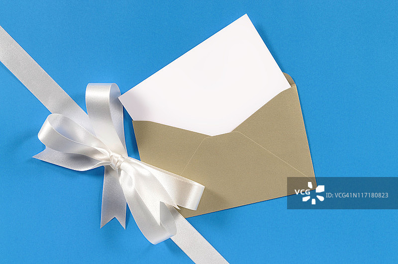 白色的礼物丝带，蓝色的纸和空白的卡片图片素材