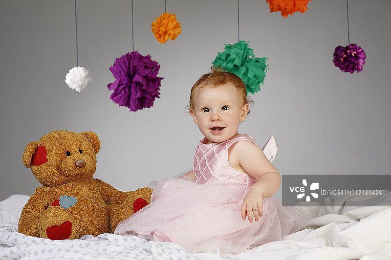快乐宝贝肖像可爱的小女孩穿着优雅的晚礼服玩玩具熊娃娃图片素材